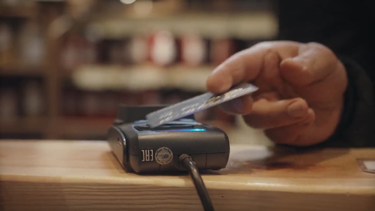 A customer completing a contactless transaction through a connected business system